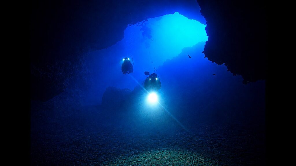 Riserva Naturale dello Zingaro (TP). L’ingresso della Grotta Grande della Ficarella introduce in una galleria, lunga circa 130 metri ed attraversata da una significativa risorgenza di acqua dolce. La grotta si formò in ambiente subaereo e venne successivamente invasa dal mare con l’innalzamento del livello marino. Nel 1981, quando venne istituita l'area protetta –la prima in Sicilia- non era ancora noto il sistema di cavità sommerse che rende questo luogo unico per comprendere l'evoluzione dell'uomo nell'area mediterranea. Foto Vincenzo Sottosanti / Archivio LIMEN.